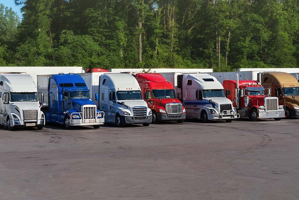 Commercial trucks parked together in a parking yard